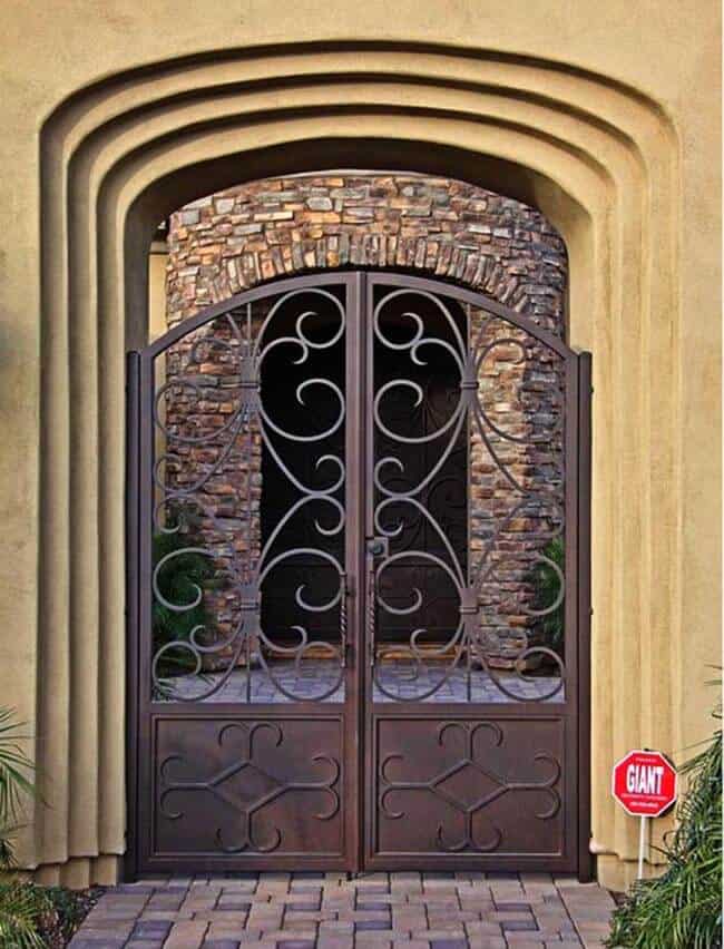 Arched wrought iron gate with oversized scrollwork and Mediterranean-inspired styling G137 MCD