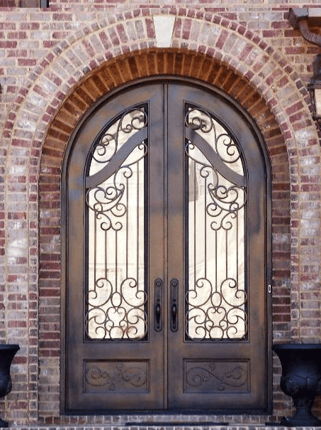 Double arched wrought iron door with bronze patina finish, ornate scrollwork and tall glass panels EL1104 MCD by Monarch Custom Doors.
