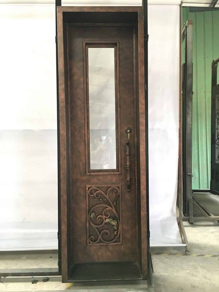 Narrow single wrought iron door with slim vertical glass and decorative lower scroll panel EL1086 MCD, handcrafted by Monarch Custom Doors.