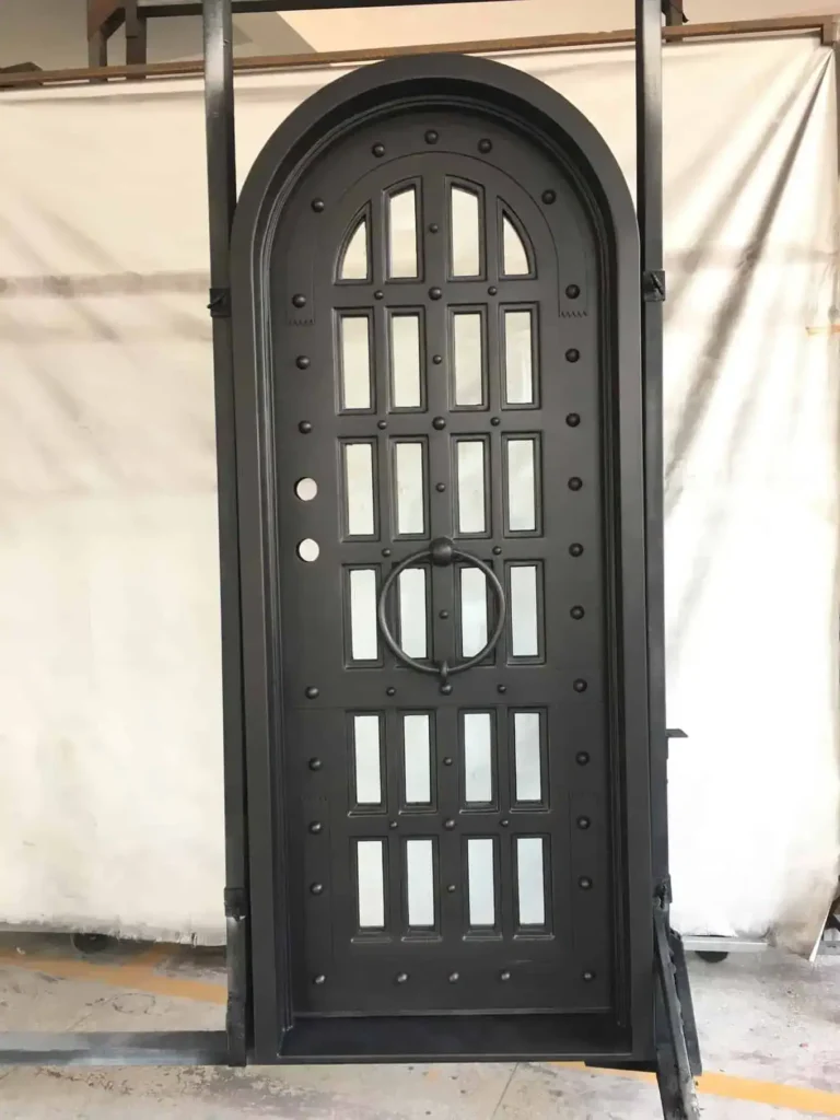 Single arched wrought iron door EL1011 MCD with vertical panel cutouts, decorative rivets, and 12-gauge wrought iron construction