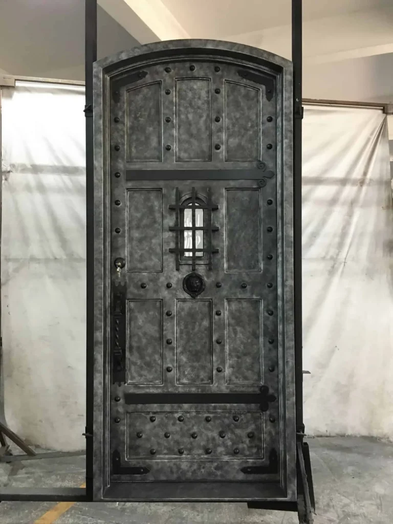 EL5059 MCD arched single wrought iron door with riveted steel panels and small iron grille window