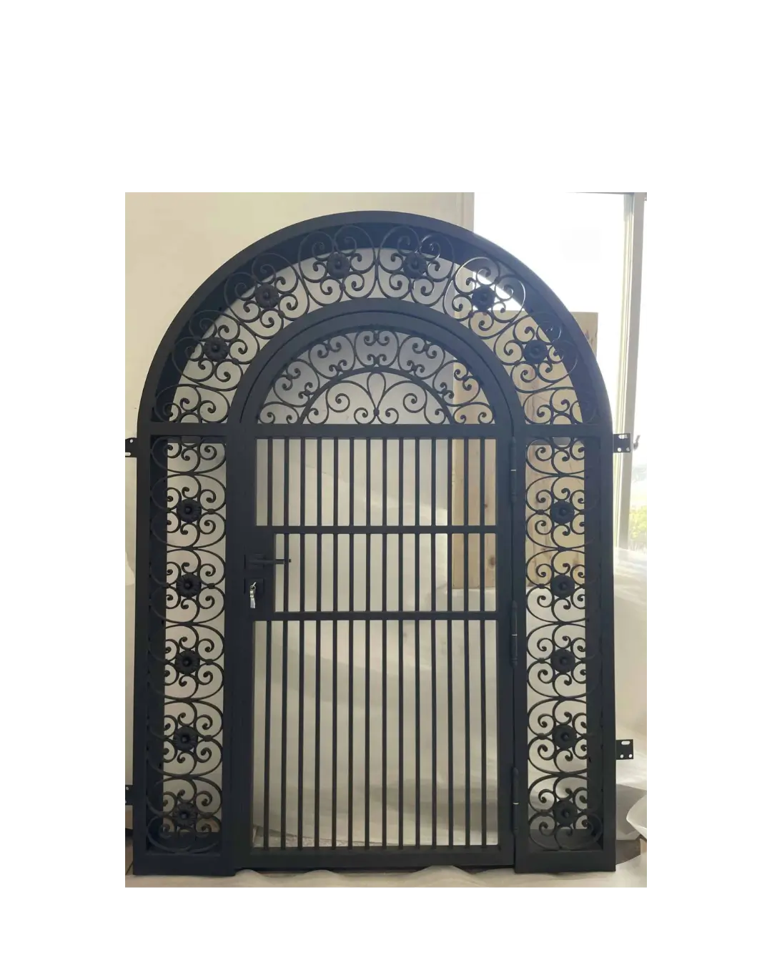 Arched wrought iron gate with decorative scrollwork and vertical security bars G103 MCD