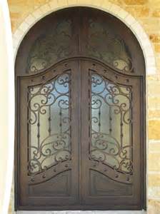 Double arched wrought iron door EL1034 MCD with decorative scroll panels and glass, handcrafted for durability and elegance.