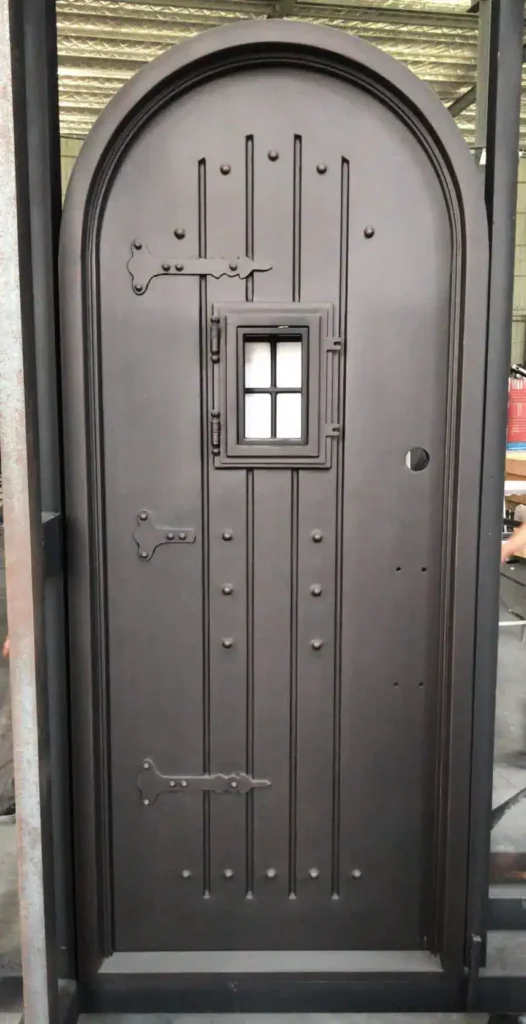 Rustic wrought iron door EL1010 with solid panel, rivets, and small square window, handcrafted for strength and charm.